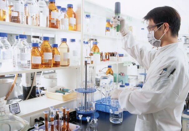 technician wearing cleanroom coveralls and mask workin in a lab