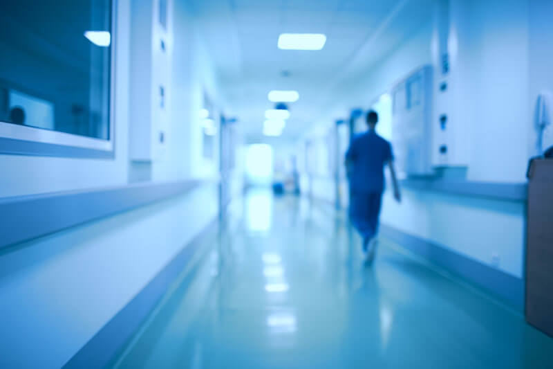 A worker walking down a Hospital hallway